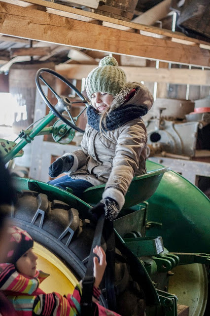 Zimowo poubierane dzieci na traktorze