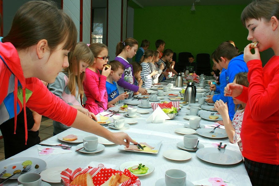 Dzieci stojące przed długim stołem
