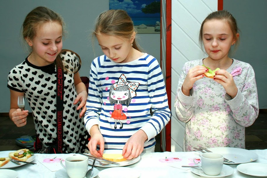 Trzy dziewczynki robiące i jedzące kanapki