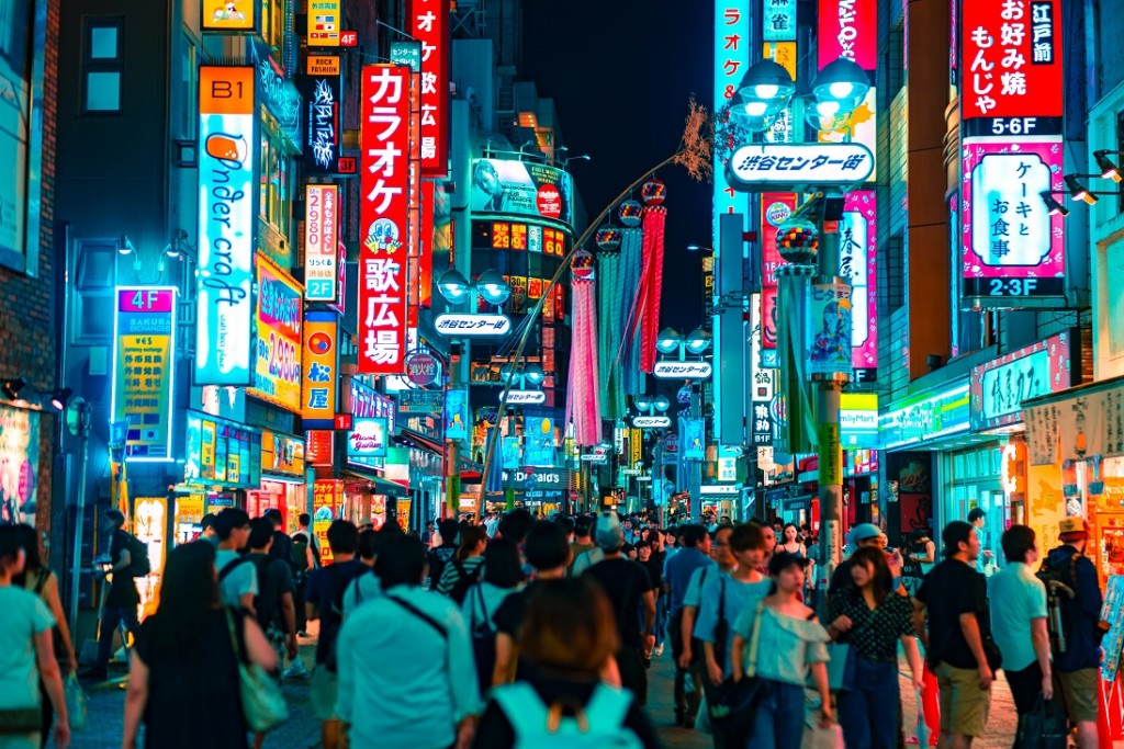 Zatłoczona ulica w Tokyo, wiele banerów i świateł