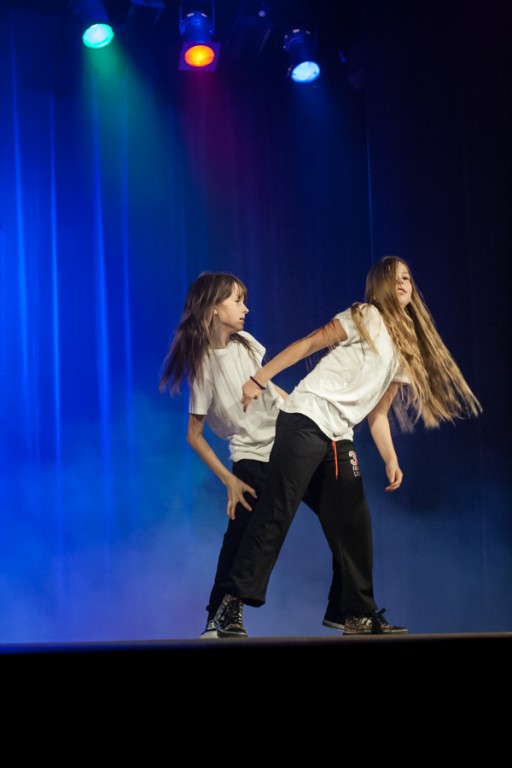 Dwie dziewczynki ubrane na czarno-biało tańczą na scenie