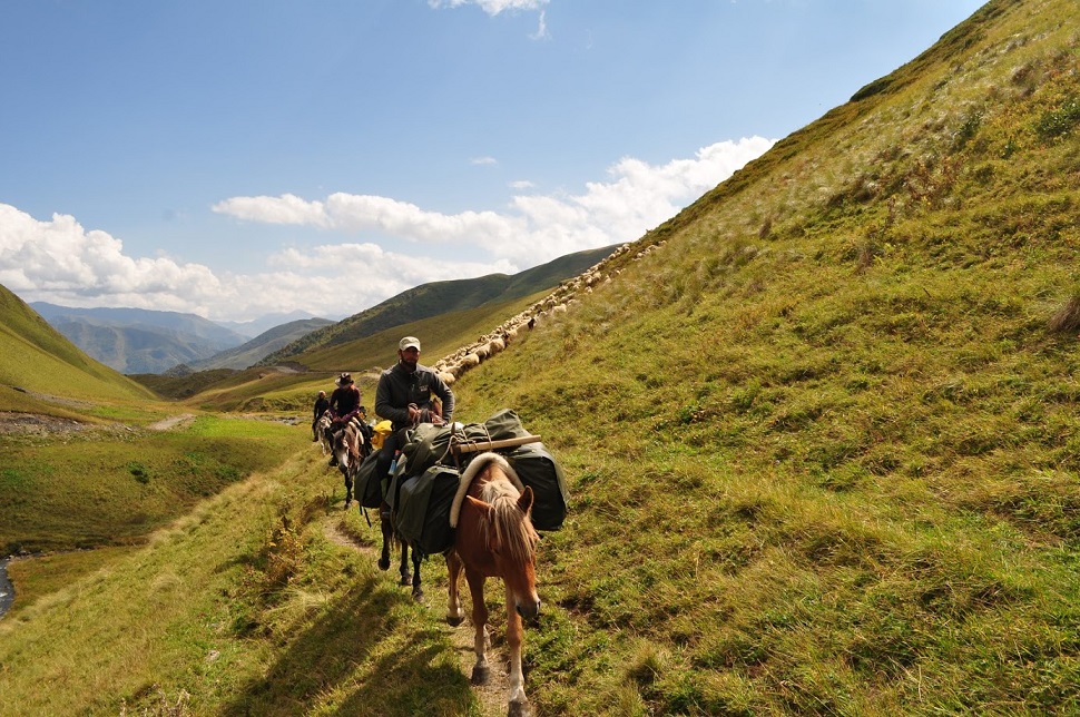 Ludzie na koniach przechodzący przez dolinę