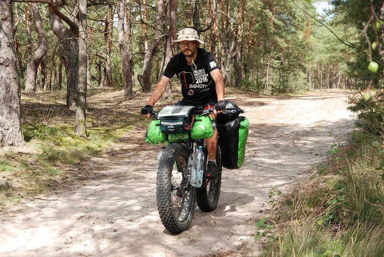Mężczyzna na motorze jadący przez las