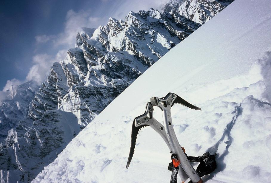 Metalowe narzędzie stojące na śniegu na tle gór