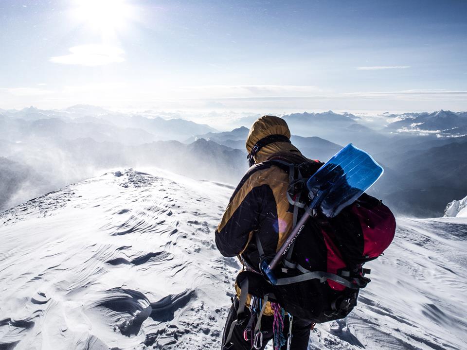 Alpinista idący przez śnieżny teren