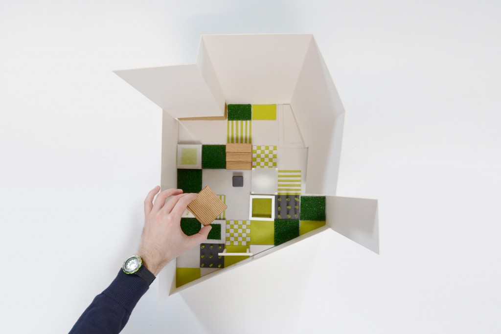 Ręka wkładająca kolorowe kształty do pudełka o nieregularnym kształcie