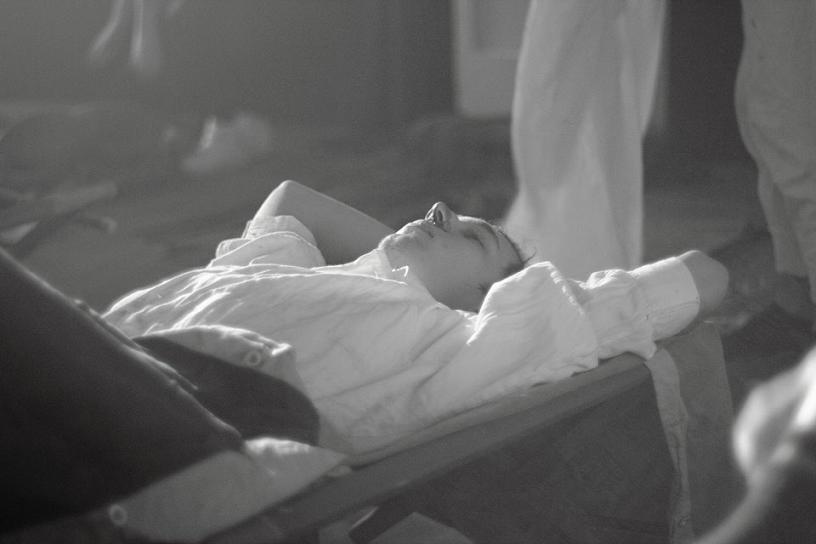 Czarno-białe zdjęcie mężczyzny w koszuli leżącego na łóżku
