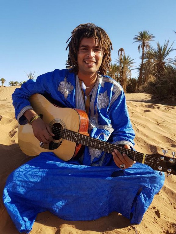 mężczyzna z gitarą na pustyni