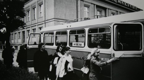 Ludzie wsiadający do autokaru przed domem kultury