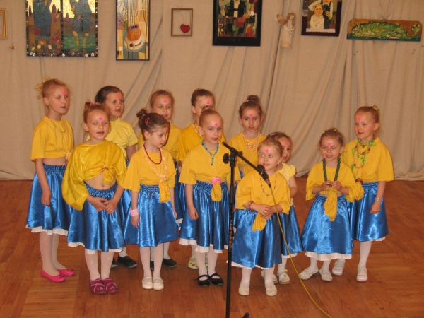 Tańczące nutki ubrane w żółto-niebieskie barwy przed mikrofonem
