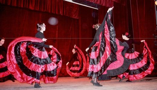 Dziewczynki ubrane w hiszpańskie sukienki i tańczące na scenie