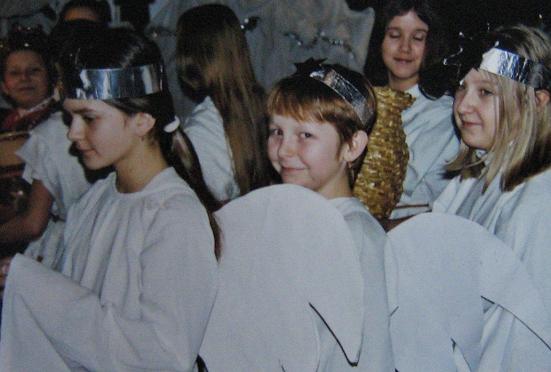 Dzieci ubrane w białe szaty i metaliczne opaski na głowach