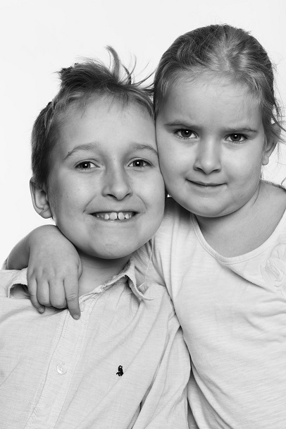 Czarno-białe zdjęcie chłopca i dziewczynki, którzy się uśmiechają