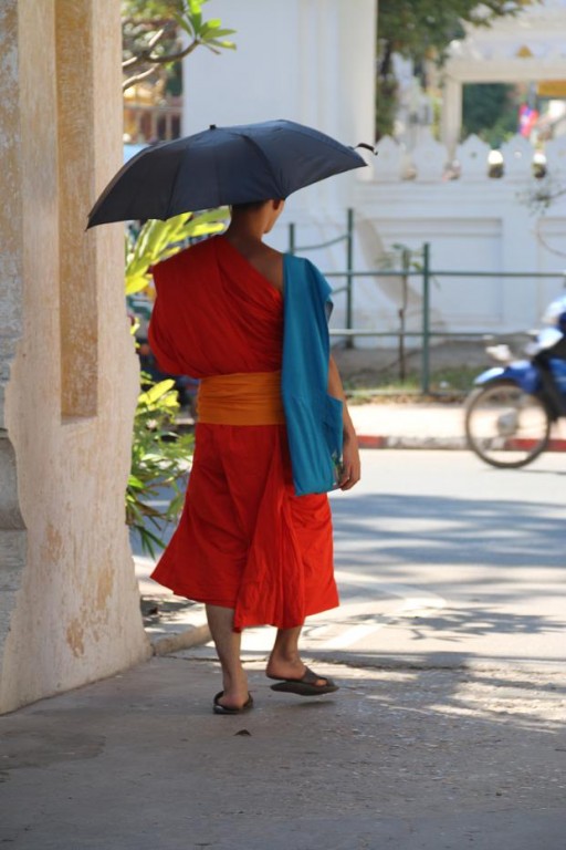 Mnich w szatach z parasolem