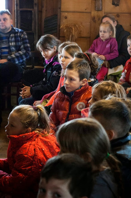 Zimowo poubierane dzieci siedzące w kółku