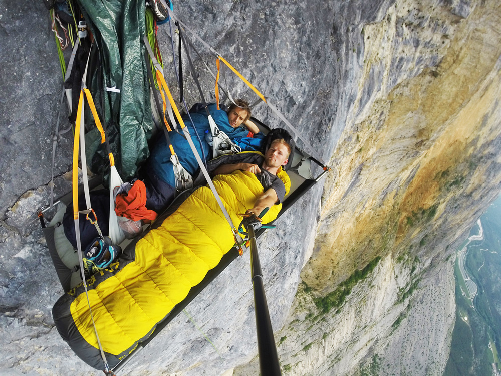 Dwójka osób leżąca nad przepaścią w powietrzu
