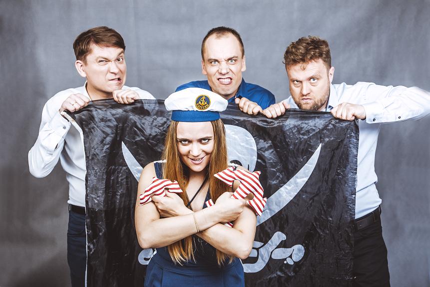 Kobieta w stroju marynarza, za nią trzech mężczyzn trzymających piracką banderę
