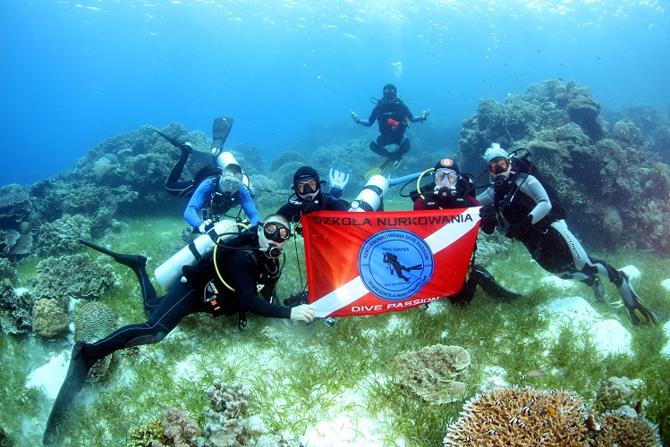 Nurkowie trzymający plakat szkoła nurkowania Dive Passion