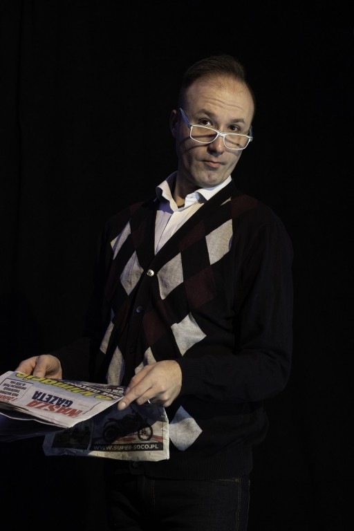 Mężczyzna w okularach z gazetą w ręku