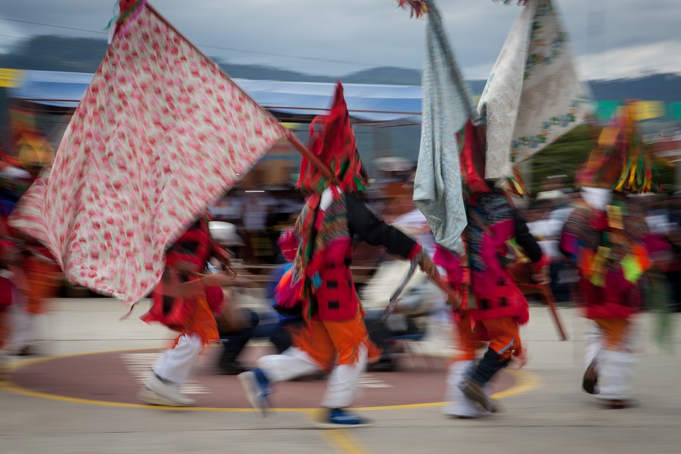 Ludzie z flagami tańczący w meksykańskich strojach ludowych