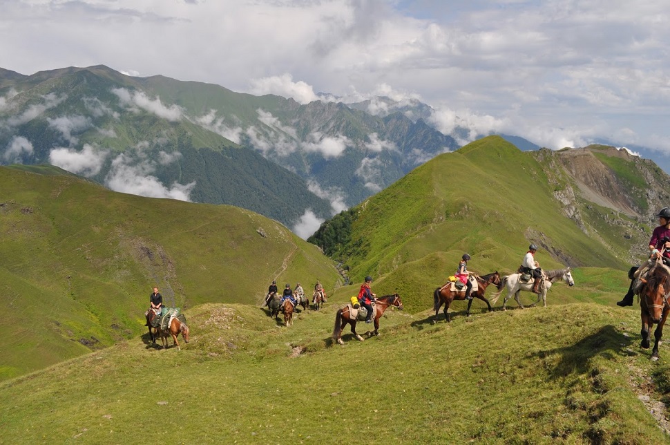 Ludzie na koniach przechodzący po górach