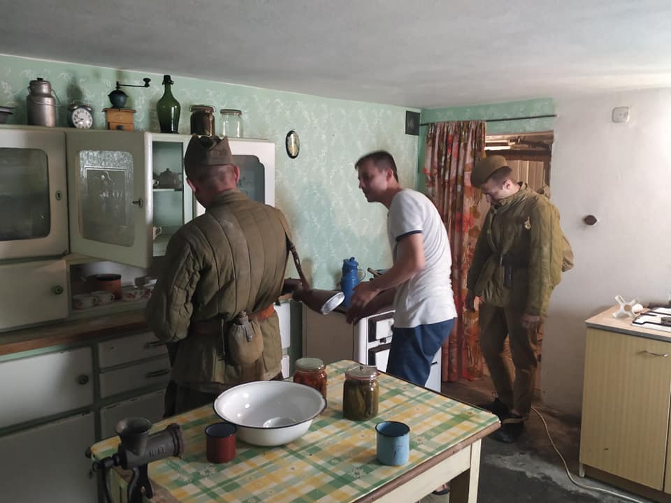 Dwóch żołnierzy z bronią i mężczyzna w kuchni