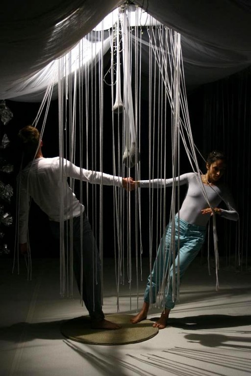 Mężczyzna i kobieta tańczący wokół wiszących nici
