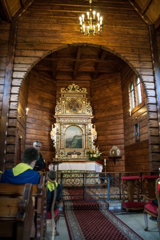 Dzieci w żółtych chustach w środku drewnianego kościoła