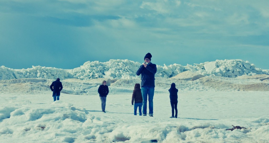 Piątka osób stojących na pustkowiu pokrytym śniegiem