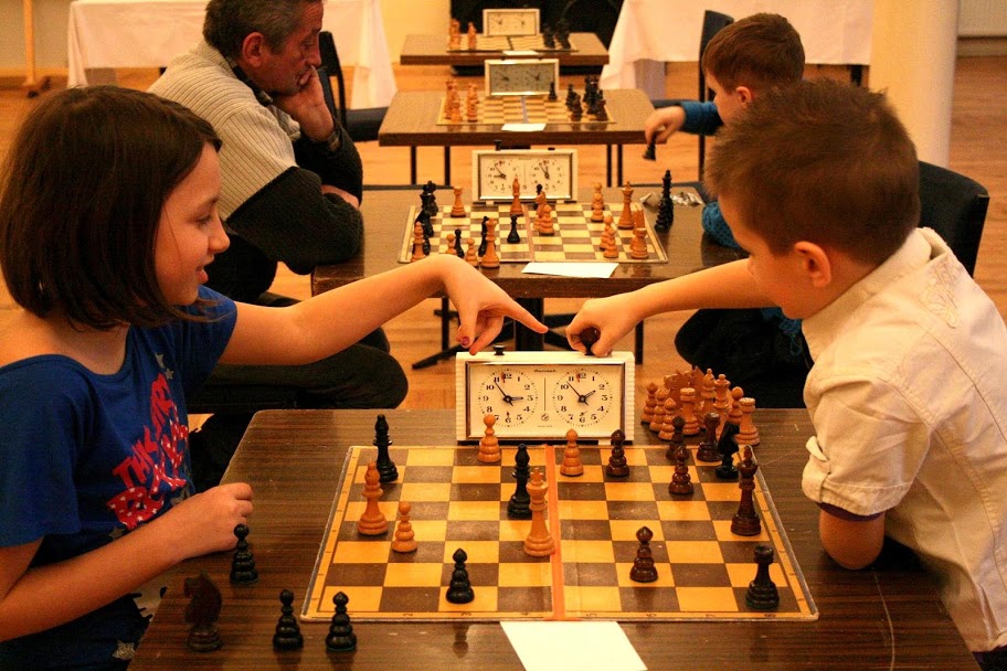Dzieci i starsi grający w szachy