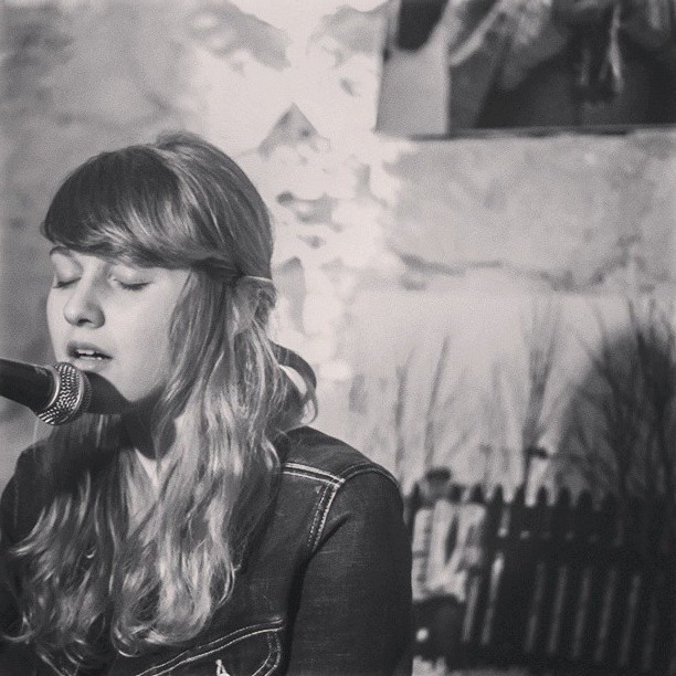 Czarno-białe zdjęcie śpiewającej do mikrofonu kobiety