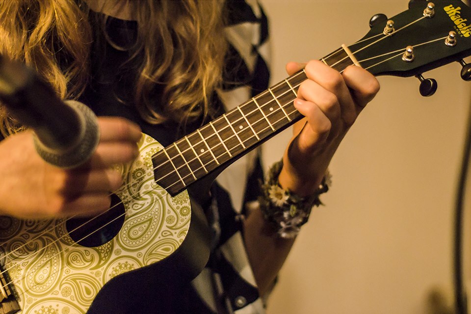 Zbliżenie na dłonie kobiety grającej na gitarze