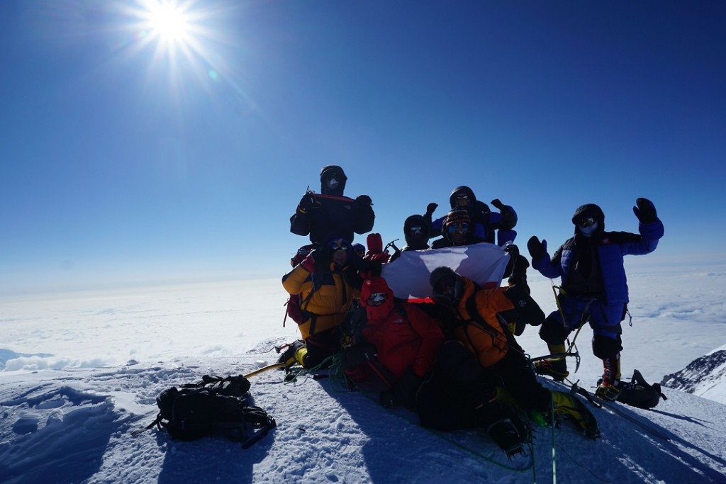Grupa wspinaczy na szczycie góry