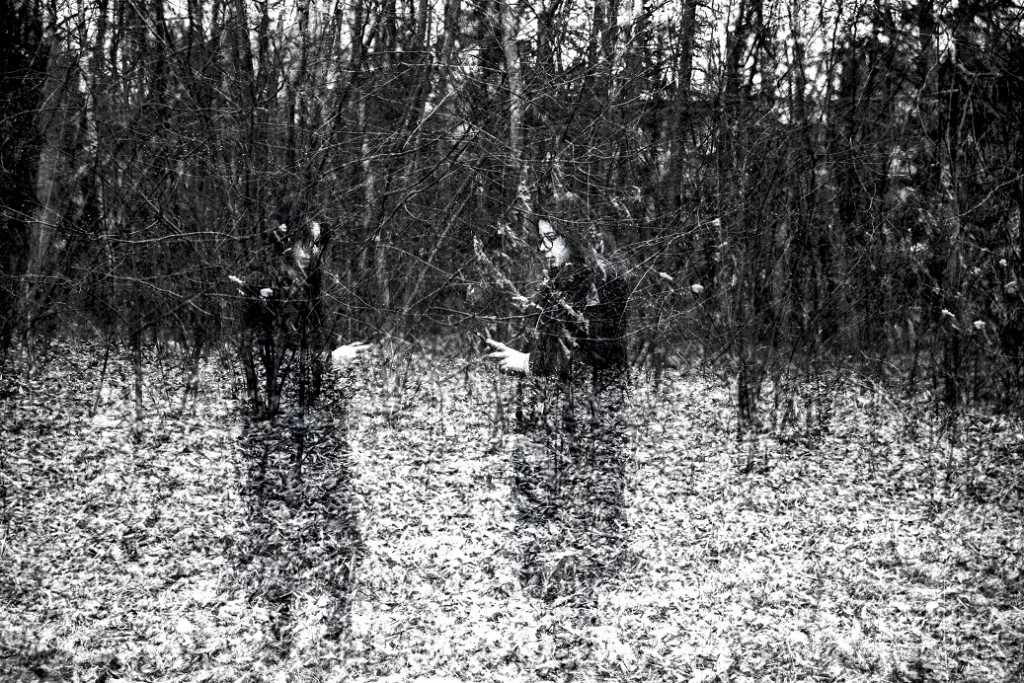 dwie kobiety z telefonami w ręku za krzakiem w lesie