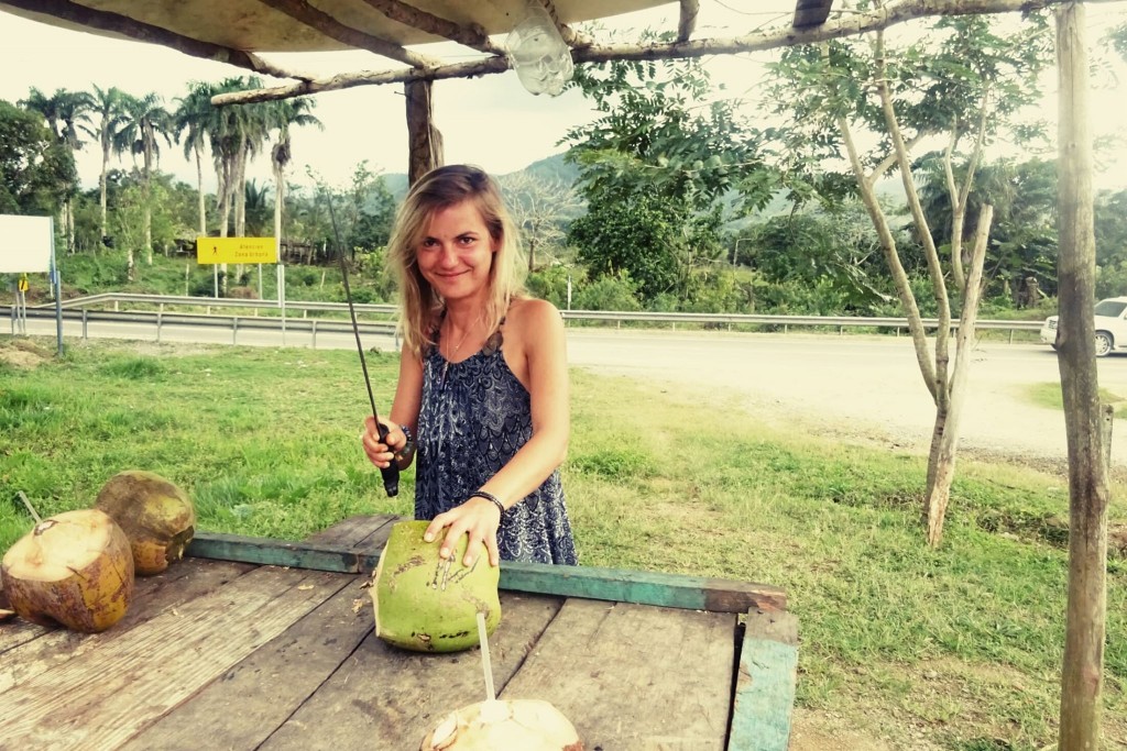 Kobieta z maczetą przy stanowisku z kokosami