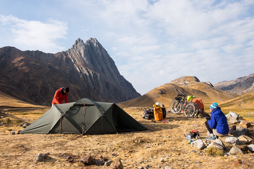 Namiot, rowery i plecaki na górzystym terenie