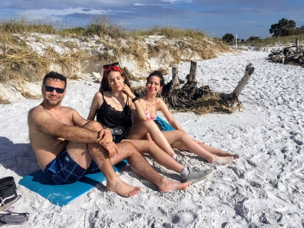 Mężczyzna i dwie kobiety siedzące na plaży