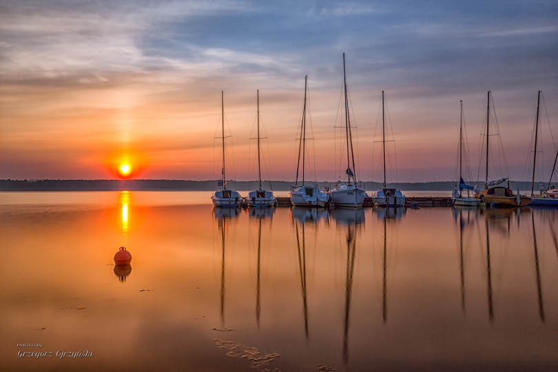 Jachty na jeziorze przy zachodzie słońca