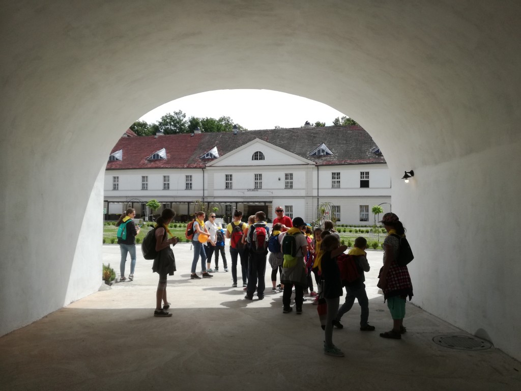 Dzieci w żółtych chustach z opiekunami stojące w tunelu