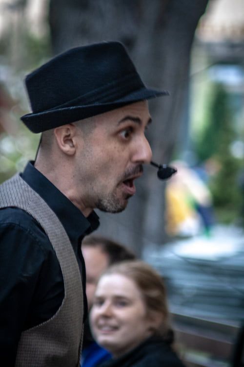 Zdjęcie przedstawia mężczyznę ze zdziwioną miną, w tle widać kobietę