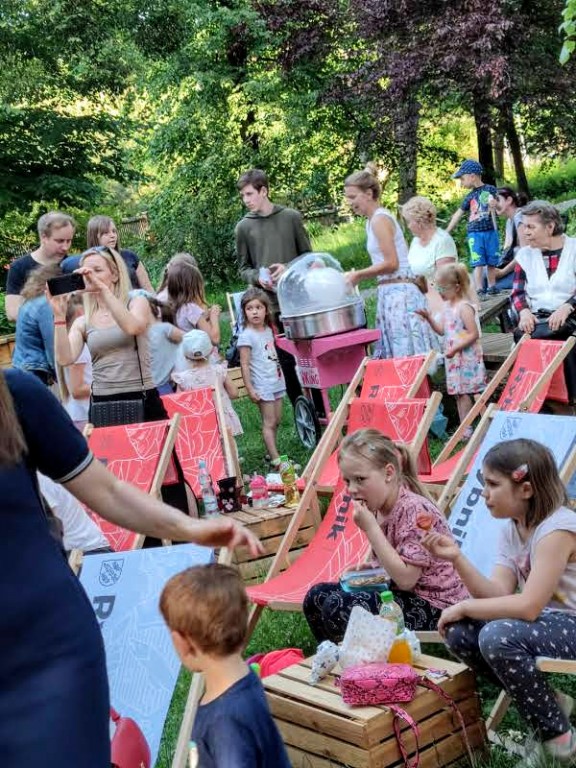 Dzieci z rodzicami siedzący na leżakach w parku