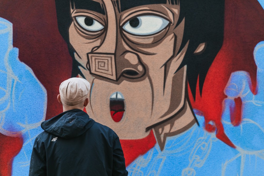 Mężczyzna spoglądający na niedokończone graffiti