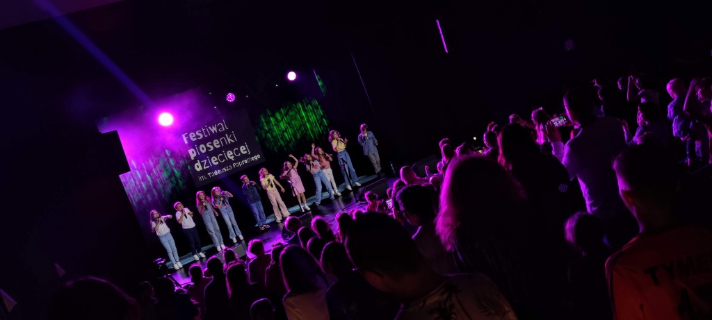 Zdjęcie przedstawia publiczność oraz wokalistów zespołu Małe TDG