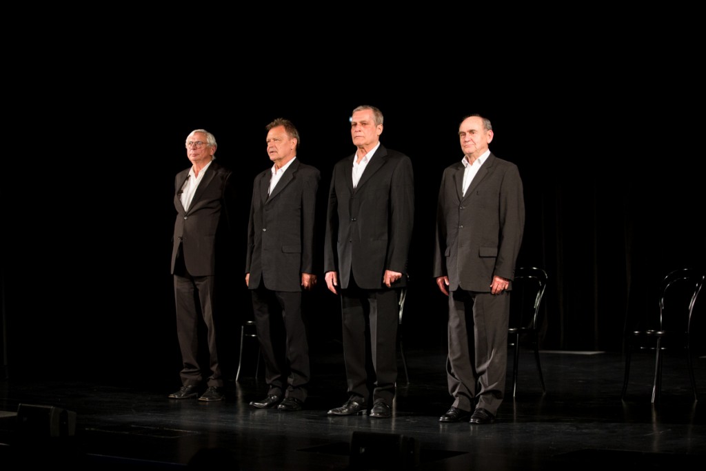 Czterech mężczyzn w garniturach stoją obok siebie