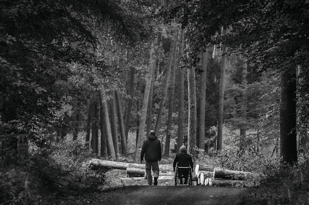 Czarno-białe zdjęcie dwóch osób idących przez las