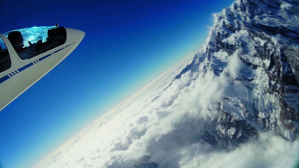 Dziub samolotu na tle gór przykrytych chmurami
