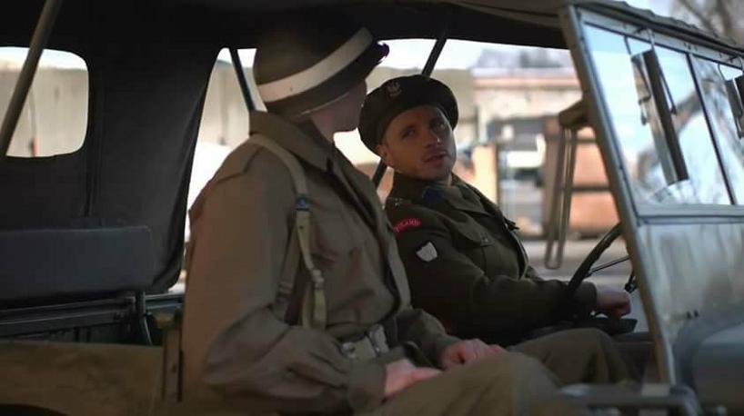 Dwóch mężczyzn ubranych w mundury wojskowe siedzą w samochodzie i rozmawiają