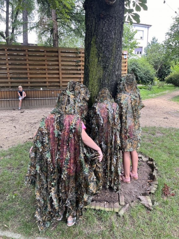 Dzieci testują peleryny maskujące.