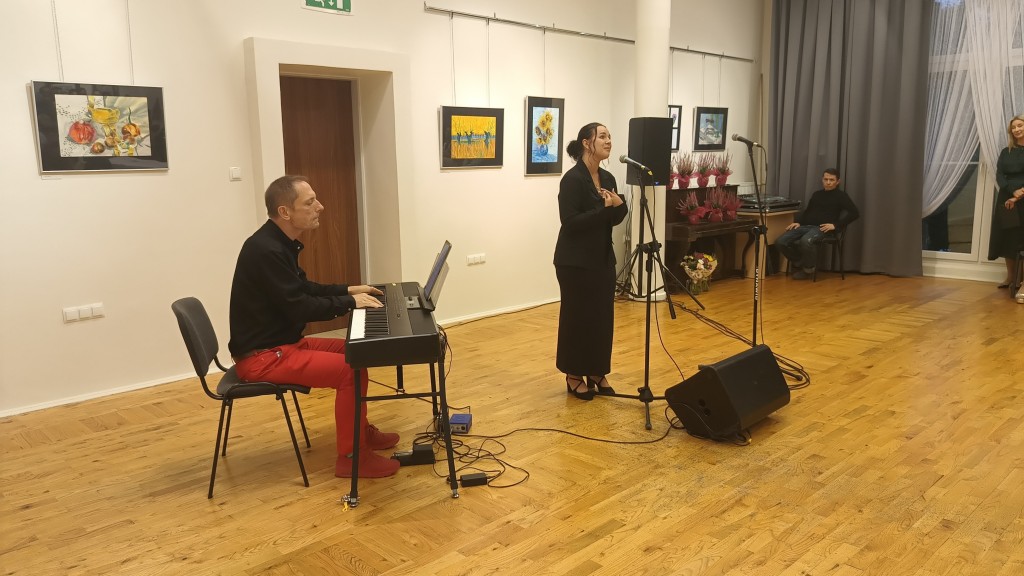 Kobieta śpiewa, a mężczyzna obok gra na keyboardzie.