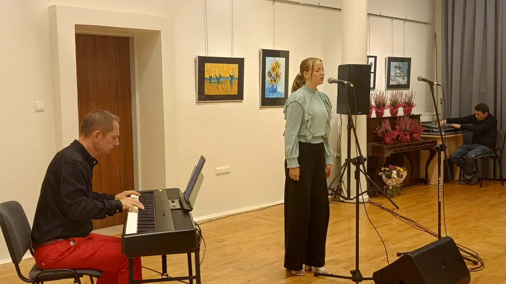 Dziewczyna śpiewa, a mężczyzna obok gra na keyboardzie.